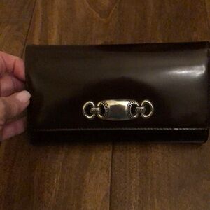Brighton glossy leather brown saddle wallet with silver saddle appliqué front.